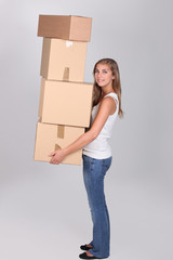 Young woman carrying four large packing boxes