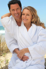 Obraz premium Portrait of couple on dunes in towelling robes