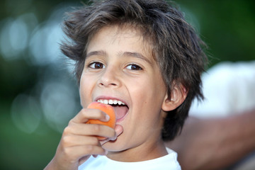 Boy eating an apricot