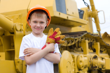 Boy is against the background of excavator.