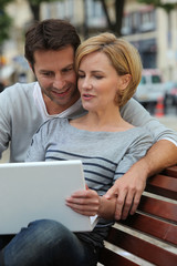 Couple on laptop on bench