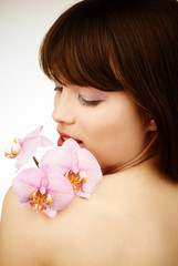 Obraz na płótnie Canvas Pink orchid on a beatiful woman's shoulder