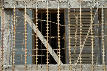 vergittertes Fenster in ehemaligem Folterzentrum - obrazy, fototapety, plakaty
