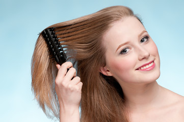Naklejka premium Close up portrait of young beautiful woman with comb