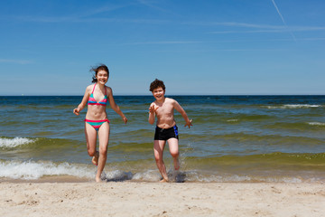 Fototapeta na wymiar Kids running on beach