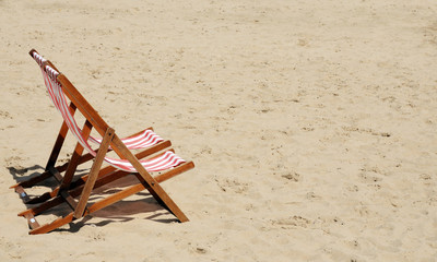 Fototapeta na wymiar Deckchairs on a sandy beach