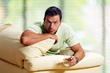 man in the living room, with empty waterglass
