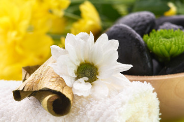 Spa,  flower on the towel, and a bowl with black stones