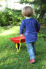 Kind mit Spielzeugschubkarre