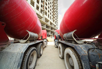 Between two concrete mixer standing near unfinished building