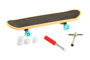 Black skateboard with yellow edge and blue wheel near tools