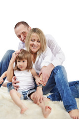 Mother, father and little daughter in white shirts and jeans