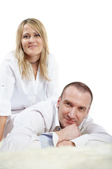 Obraz premium Man in white shirt lies on shaggy carpet, woman sit