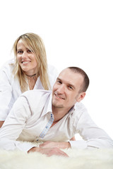 Obraz premium Man in white shirt lies on shaggy carpet, woman sit