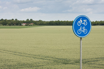 Traffic sign for bicycle and moped in rural landscape