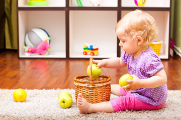 little girl playing with apple and lemons