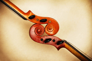 Naklejka premium two old violin scrolls detail in ambient light