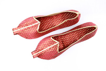 Pair of traditional Indian shoes on white.