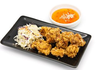 fried chicken in black plate with sauce