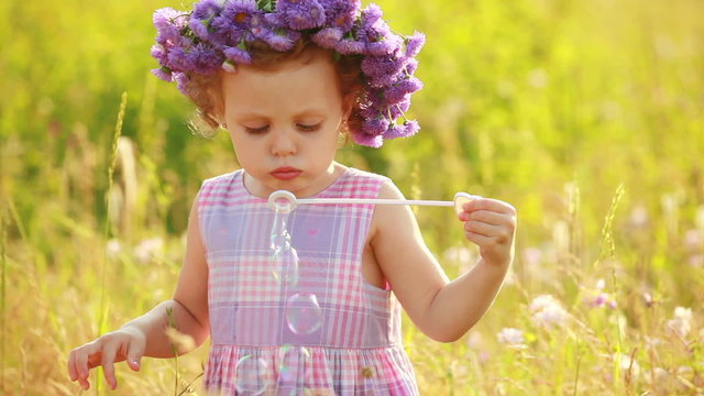 Child with boubles in the meadow