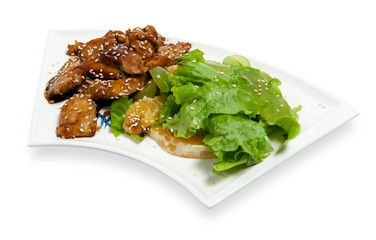 pieces of chicken in sauce with salad