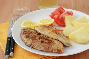 fried fish with boiled potato and tomato