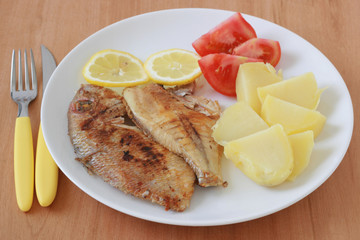 fried fish with boiled potato and tomato