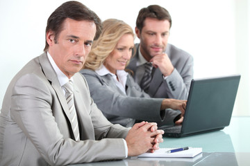 Businessman with colleagues and a laptop computer
