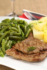 Beef meat slices with potatoes, beans and rosemary