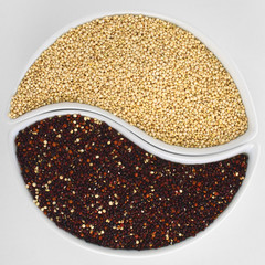 Raw red and white quinoa grains in two bowls