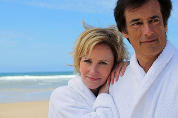 couple in robes on the beach