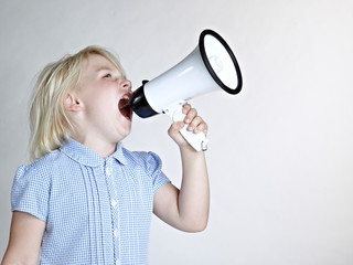 Cute blond girl shouting loud through megaphone