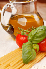 pasta, olive oil and tomatoes on the wood background