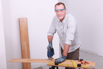 Man cutting floorboard