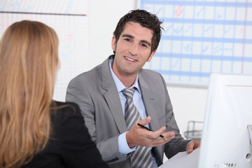 Man working at a computer with a customer