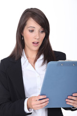 Naklejka premium Young woman surprised at her clipboard