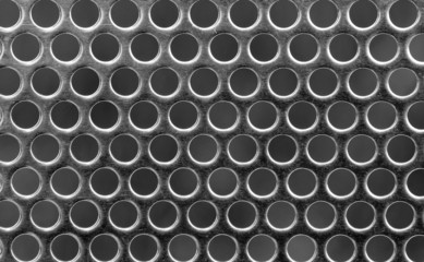 Techno background - metal surface with round perforations.
