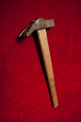 old sledge hammer with wooden handle on a red background