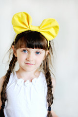 Funny little brunette girl with yellow bow
