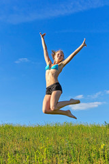 Fototapeta na wymiar beautiful girl jumping against the blue sky