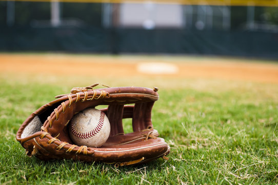Old Baseball and Glove on Field