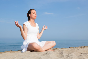 Fototapeta na wymiar Beautiful Young Woman Doing Yoga Exercises at Seaside
