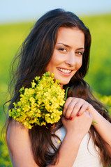 girl with flowers at summer field