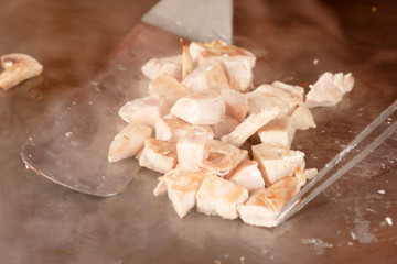 Chef frying meat in a pan