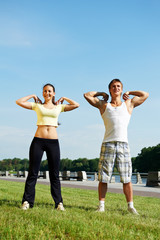 Young man and woman doing stretching exercises