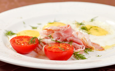 fried eggs with bacon and vegetables