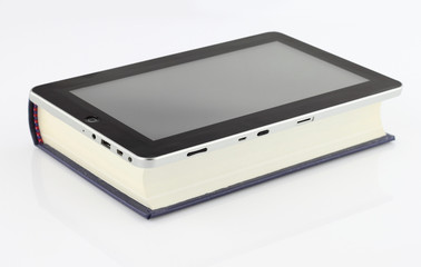 Tablet computer on book  isolated on white