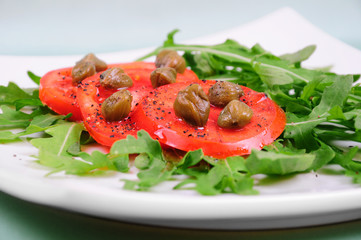 Salad with fresh tomatoes, capers and arugula