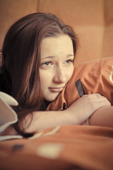 Closeup portrait of young pretty girl laying on her bed