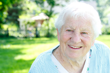 Happy senior lady smiling in spring garden